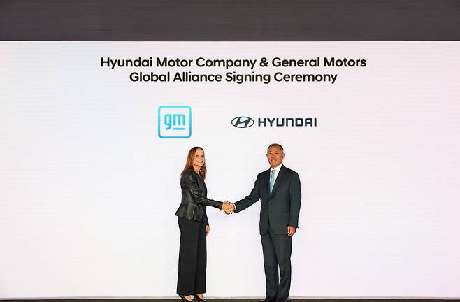 Hyundai Motor Group Executive Chair Chung Euisun (right) and General Motors CEO Mary Barra shake hands after the two automakers sign a partnership agreement at Genesis House New York. (Hyundai Motor Group)