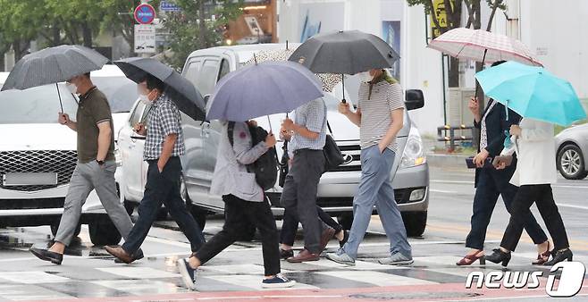 (대전ㆍ충남=뉴스1) 최형욱 기자 = 13일 대전·충남은 흐린 가운데 낮부터 늦은 오후 사이 소나기가 내리는 곳이 있을 것으로 예보됐다. 대전 서구 대전시청 인근 도로에서 시민들이 우산을 쓰고 이동하고 있다. /뉴스1 ⓒ News1 김기태 기자