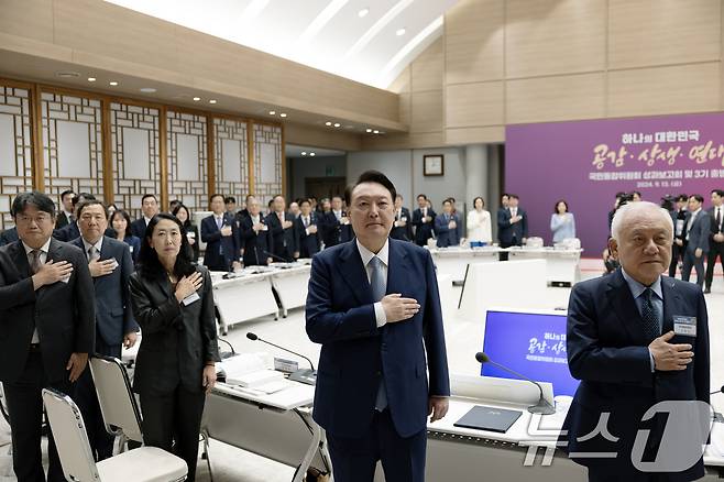 윤석열 대통령이 13일 서울 용산 대통령실 청사에서 열린 대통령 직속 국민통합위원회 성과 보고회 및 3기 출범식에서 김한길 국민통합위원장, 국민통합위 민간위원 등 참석자들과 함께 국기에 경례하고 있다. (대통령실 제공) 2024.9.13/뉴스1 ⓒ News1 송원영 기자