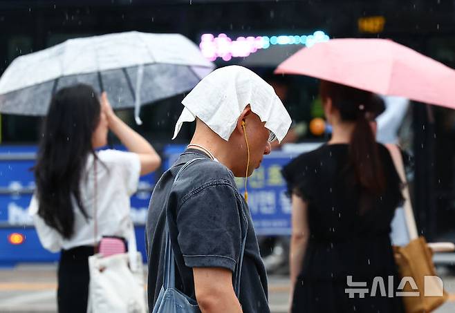 [서울=뉴시스] 김근수 기자 = 서울 시내에 소나기가 내리는14일 서울 종로구 세종대로에서 시민들이 비를 피해 퇴근하고 있다. 2024.08.14. ks@newsis.com