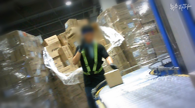 지난 8월 21일 촬영한 쿠팡 제주 서브허브의 내부 모습. 일용직 노동자 뒤로 박스가 키보다 높게 쌓여 있다. 모두 컨베이어벨트 위로 옮겨야 하는 것들이다.