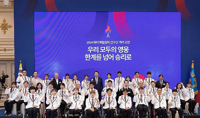 윤석열 대통령과 김건희 여사가 13일 청와대 영빈관에서 열린 '2024 파리 패럴림픽 선수단 격려 오찬'을 마친 뒤 선수단 및 참석자들과 기념 촬영을 하고 있다. 연합뉴스