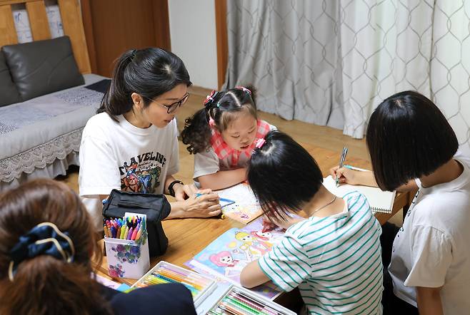 윤석열 대통령 부인 김건희 여사가 추석 명절 연휴인 15일 서울 은평구 다움장애아동지원센터를 방문해 어린이들의 밑그림을 도와주고 있다. /대통령실