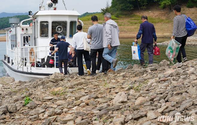 지난 7일 충북 제천시 한수면 서창리 묘소 앞에서 성묘를 마친 최정훈 씨 가족이 뭍으로 돌아갈 배를 타고 있다.