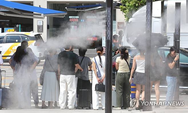 무더운 추석 예고 (부산=연합뉴스) 강선배 기자 = 추석 연휴를 하루 앞둔 13일 부산에 폭염경보가 발효된 가운데 부산역 앞 횡단보도를 지나는 귀성객 등 시민들 사이로 쿨링포그가 가동되고 있다.
    부산기상청은 "폭염특보가 발효된 부산에선 당분간 최고 체감온도가 33도 이상으로 올라 매우 무덥겠다"고 전했다. 2024.9.13 sbkang@yna.co.kr