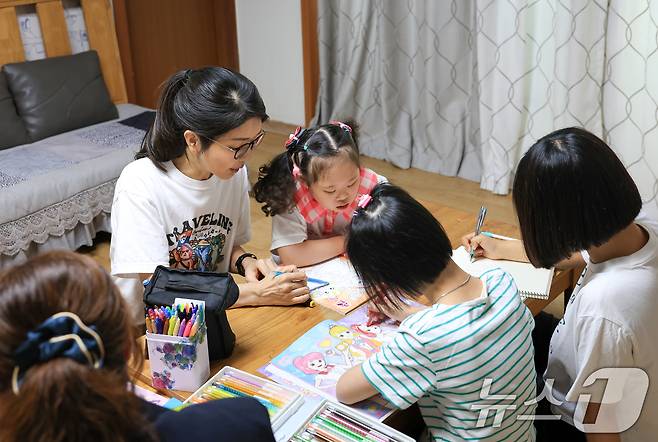 윤석열 대통령 부인 김건희 여사가 15일 서울 은평구 장애아동거주시설인 다움장애아동지원센터를 방문, 보조 교사와 함께 어린이들이 그림책에 색연필로 색칠하는 것을 도와주고 있다. (대통령실 제공) 2024.9.15/뉴스1 ⓒ News1 송원영 기자