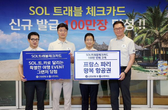 신한은행 본점에서 지난 7월 열린 '신한 SOL트래블 체크카드' 발급 100만장 달성 기념행사에 참석한 이해창(맨 오른쪽) 신한은행 외환본부장과 장재영(맨 왼쪽)신한카드 멤버십본부장이 이벤트 당첨 고객과 기념촬영하고 있다. [신한은행 제공]