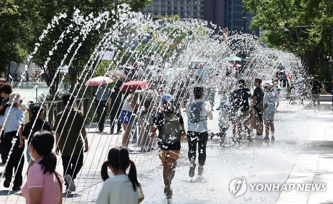 지난 16일 서울 종로구 광화문광장에서 시민과 외국인 관광객들이 분수터널을 지나고 있다. [연합뉴스]