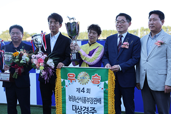 박계화 한국마사회 제주본부장(오른쪽에서 두 번째)이 제4회 농림축산식품부장관배 대상경주에서 우승한 문현진 기수(가운데)에게 시상하고 관계자들과 함께 포즈를 취하고 있다.  [사진=한국마사회 제주본부]