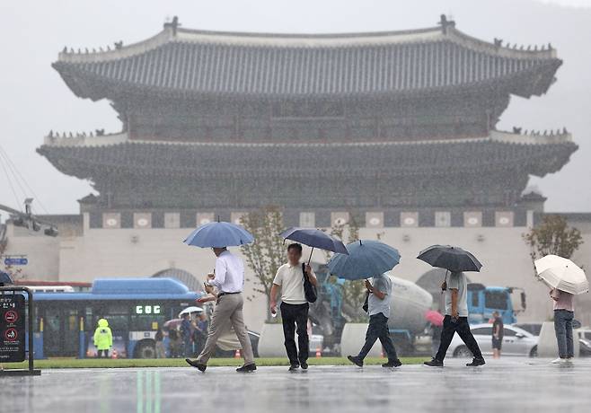 Pedestrians walk past Gwanghwamun Square with umbrellas in the middle of a rain shower on Sept. 5. (Yonhap)