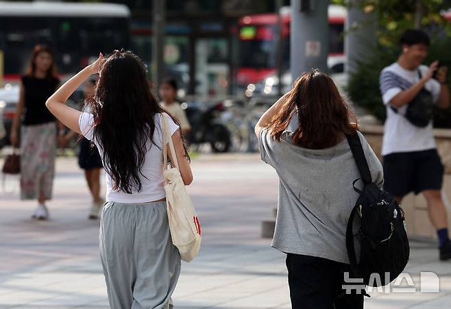 [서울=뉴시스] 김명년 기자 = 서울에 폭염경보가 내려진 18일 오후 서울 송파구 잠실네거리에서 시민들이 손바닥으로 햇빛을 가린 채 이동하고 있다. 2024.09.18. kmn@newsis.com