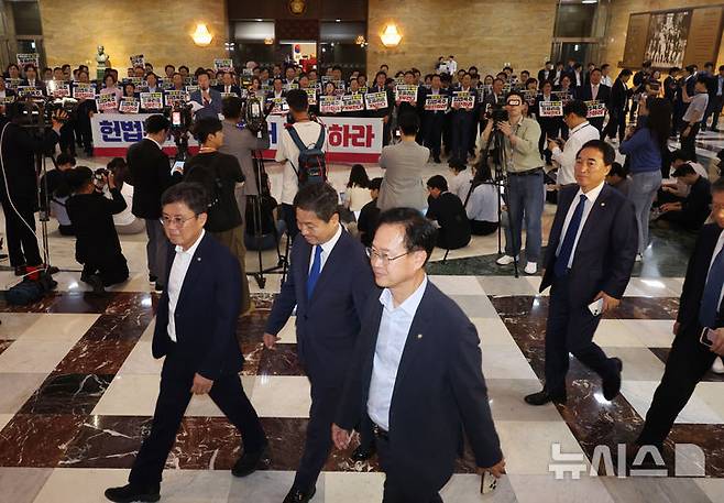 [서울=뉴시스] 고승민 기자 = 더불어민주당 의원들이 19일 서울 여의도 국회에서 열린 제418회 국회(정기회) 제8차 본회의에 참석하고 있다.이들 뒤로 국민의힘 의원들이 입법 폭주 및 포퓰리즘 규탄 등의 피켓을 들고 구호를 외치고 있다. 2024.09.12. kkssmm99@newsis.com