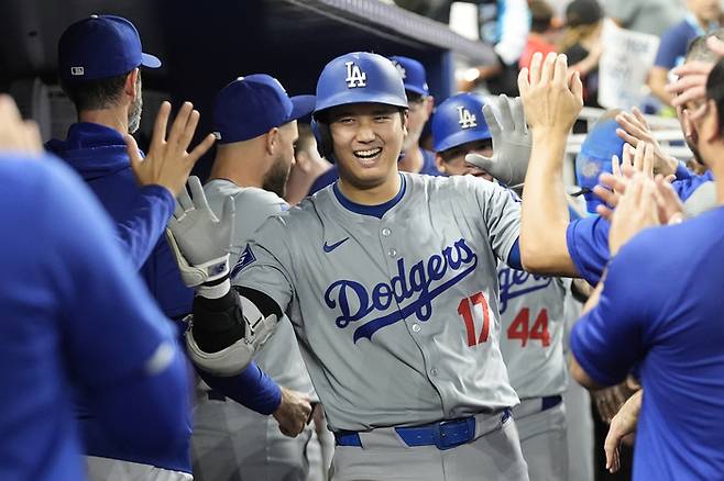 오타니 쇼헤이가 20일 미국 마이애미 론디포 파크에서 열린 MLB 마이애미 말린스와 경기에서 6회초 홈런을 터트린 뒤 동료들의 축하를 받으면서 활짝 웃고 있다. [사진 = AP 연합뉴스]