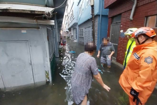 21일 오전 부산 부산진구 범천동 한 마을 골목이 폭우로 사람의 무릎 높이까지 물에 잠겨 있다. /연합뉴스