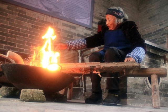 상악고촌 귀인리의 한 할머니가 장작불을 피우고 있다. ⓒ최종명