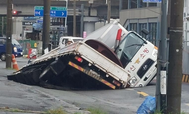 부산에 대형 땅꺼짐 현상이 발생해 트럭 2대가 빠져있다.연합뉴스