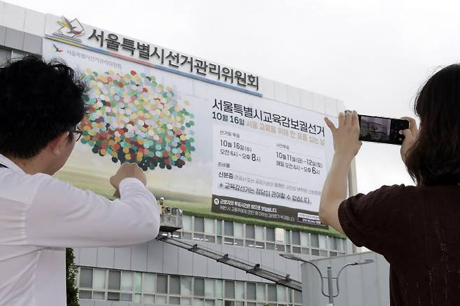 서울시선거관리위원회가 12일 서울 종로구 서울시선거관리위원회 청사 외벽에 서울시교육감보궐선거 홍보 현수막을 게시하고 있다. (사진=뉴시스)