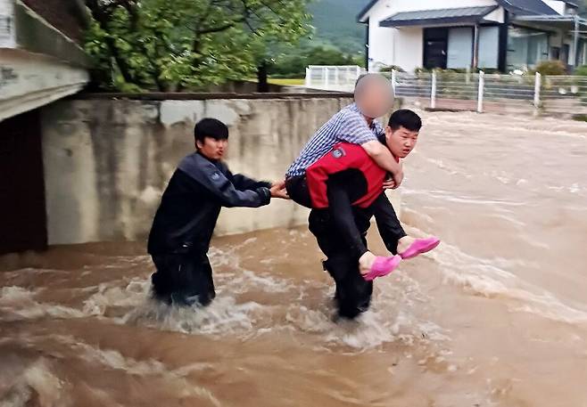 21일 오후 전남 여수시 소라면 한 주택이 침수돼 소방 당국이 주민들을 구조하고 있다. /연합뉴스