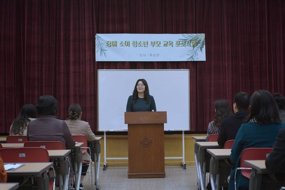 영화 ‘그녀에게’에 주인공 상연이 듣는 장애 부모 강연에 강사로 출연한 류승연 작가. 이 장면에서 "장애인은 오래 사랑받을 사람(長愛人)"이라는 풀이를 들려준다. 아들이 초교 1년 때 다른 장애아 엄마에게 들은 뒤 새겨온 말이라고 한다. 사진 영화로운형제