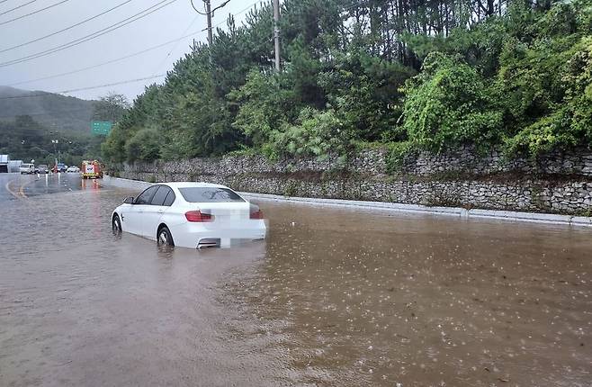 A vehicle is stranded on a road in Janggye-myeon, Jangsu-gun, North Jeolla Province, Saturday, as heavy rain pours down. (Yonhap)