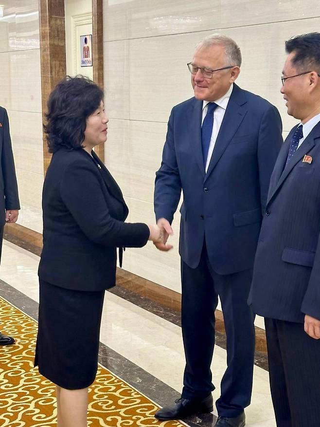 North Korean top diplomat Choe Son-hui (left) shakes hands with Aleksandr Matsegora, the Russian envoy to North Korea, as she leaves for the fourth Eurasian Women’s Forum held in St. Petersburg, Russia. (Yonhap)