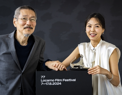 배우 김민희(오른쪽)와 홍상수 감독이 지난달 17일(현지시간) 스위스 로카르노영화제에서 최우수연기상을 받은 뒤 손을 잡고 있다.[EPA연합뉴스]