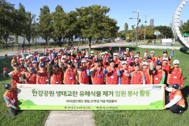 SK브로드밴드 임직원들이 23일 창립 27주년을 맞아 서울 이촌 한강공원에서 환경 정화 봉사활동을 펼친 후 사진을 찍고 있다. SK브로드밴드 제공