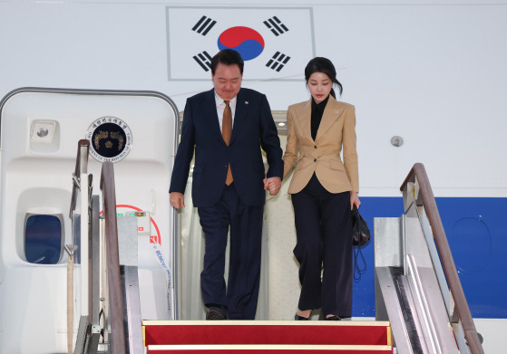 President Yoon Suk Yeol, left, and first lady Kim Keon Hee disemark from the presidential airplane at Seoul Air Base in Seongnam, Gyeonggi, after completing an official visit to the Czech Republic on Sunday morning. [YONHAP]