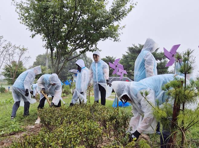 송악읍 팔아산 공원 산책로 일대에 영산홍 4000본을 식재하고 있는 현대제철 해피프리즘봉사단. 현대제철  