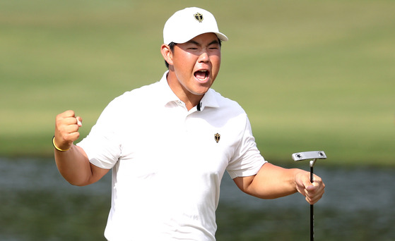 Tom Kim celebrates a putt made by teammate Kim Si-woo on the 13th green during day three of the 2022 Presidents Cup at Quail Hollow Country Club on Sept. 24, 2022 in Charlotte, North Carolina. [GETTY IMAGES]