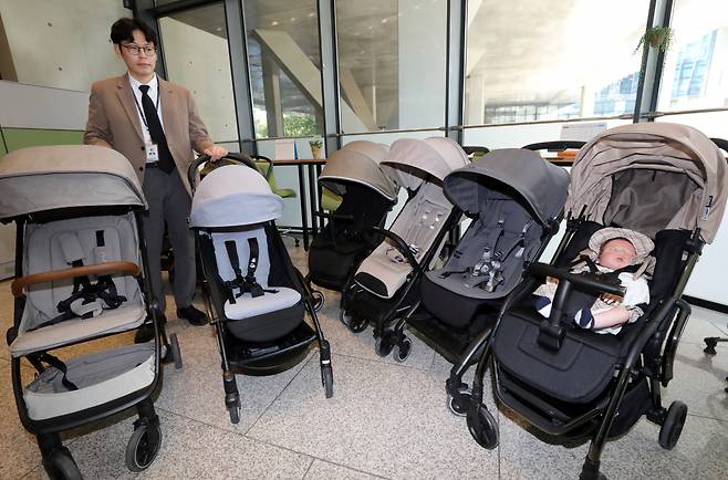 한국소비자원이 24일 오전 정부세종청사 공정거래위원회 기자실에서 주요 브랜드 휴대용 유모차 8개 제품의 기본 성능, 섬유 품질, 내구성, 사용 편의성 등을 조사한 결과를 발표했다. 사진은 직원이 시험 평가한 유모차를 살펴보는 모습. [연합]