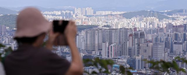 25일 서울 남산을 찾은 시민이 시내와 아파트단지를 바라보고 있다. 뉴스1