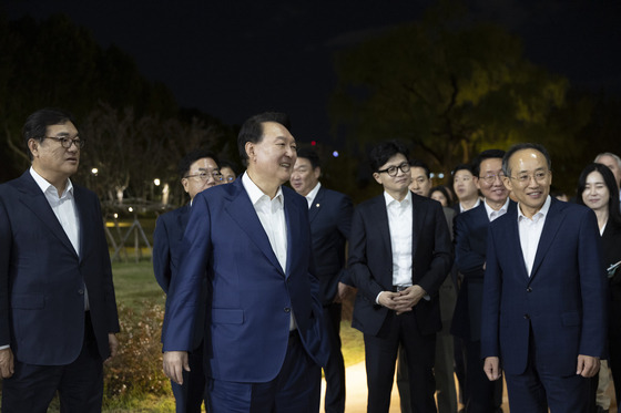 President Yoon Suk Yeol, center left, takes a stroll with conservative People Power Party (PPP) Chairman Han Dong-hoon, center right, and other PPP leaders after a dinner meeting at the presidential office in central Seoul on Tuesday. [PRESIDENTIAL OFFICE]