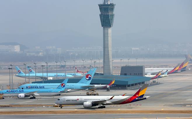 Airplanes of Korean Air and Asiana Airlines are seen on runways of Incheon International Airport in February. [NEWS1]