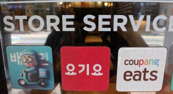 서울 강서구의 한 음식점에 3대 배달 플랫폼 의 스티커가 붙어있다. 중개수수료가 9.7~9.8%까지 오르면서 자영업자의 시름이 깊어지고 있다. [뉴시스]