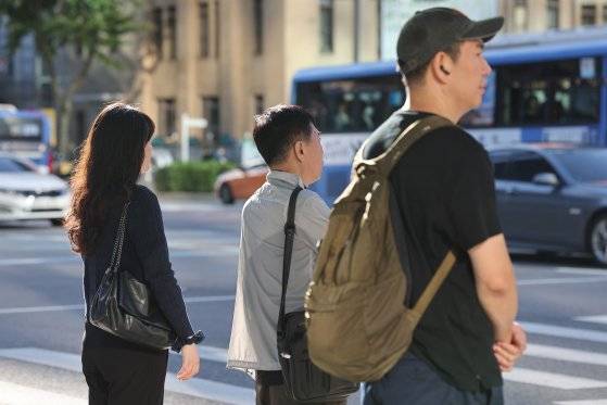 선선한 가을 날씨를 보인 23일 오전 서울 광화문네거리에서 긴소매와 반팔을 입은 시민들이 횡단보도 신호를 기다리고 있다. 연합뉴스