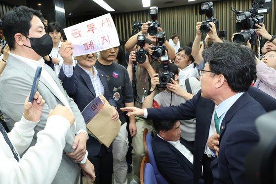 지난 24일 열린 민주당 금투세 토론회. 한국주식투자자연합회 회원들이 토론회 방청을 막는 것에 항의하고 있다. 연합뉴스