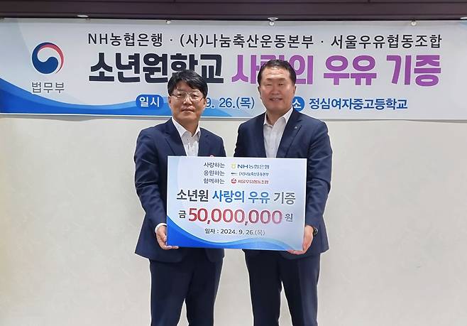 26일 경기도 안양 정심여자중고등학교에서 열린 사랑의 우유 나눔 행사에서 이영면(왼쪽) 법무부 범죄예방정책국장과 김문기 NH농협은행 부행장이 기념촬영을 하고 있다. [NH농협은행 제공]