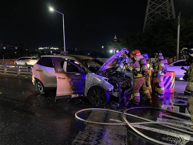 [양산=뉴시스] 26일 오후 6시49분께 경남 양산시 남부동의 일반도로에서 신호 대기 중이던 스포츠유틸리티차량(SUV)에서 불이 났다. 소방대원들이 화재를 진압하고 있다. (사진=경남소방본부 제공) 2024.09.27. photo@newsis.com *재판매 및 DB 금지