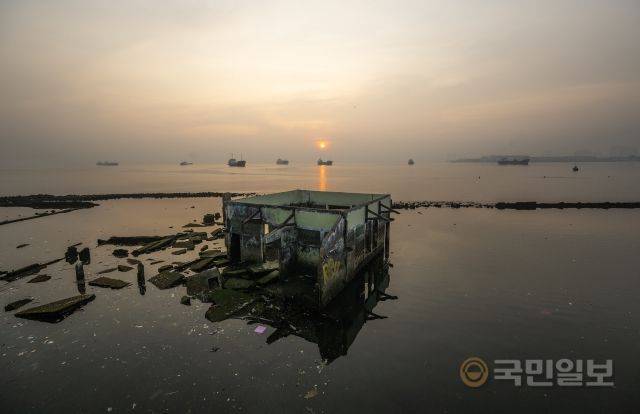 기후 변화에 따른 해수면 상승은 이미 현실이 된 재앙이다. 지난달 27일 자카르타 북부 해안에 위치한 왈라두나 사원에서 뒤로 해가 떠오르고 있다.