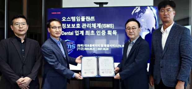 김해성 오스템임플란트 대표(사진 왼쪽에서 세 번째)와 손준배 OW개발총괄연구소장(두 번째), 김태용 정보시스템연구소장(네 번째), 최치형 IT인프라기획팀장이 ‘정보보호 관리체계 인증서’를 들고 기념 촬영을 하고 있다./사진 제공=오스템임플란트