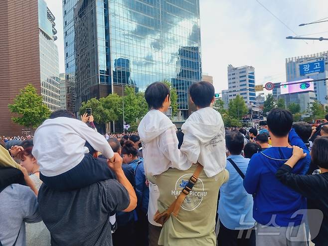 국군의 날 시가행진을 지켜보는 시민들. 한 남성이 두 아이를 한꺼번에 무등을 태우고 있다. 2024.10.01/뉴스1 박혜연 기자