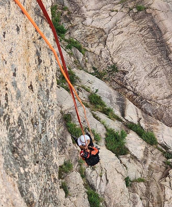 절벽 아래로 등산객과 내려오는 산악구조대원 [강원특별자치도소방본부 환동해특수대응단 제공. 재판매 및 DB 금지]