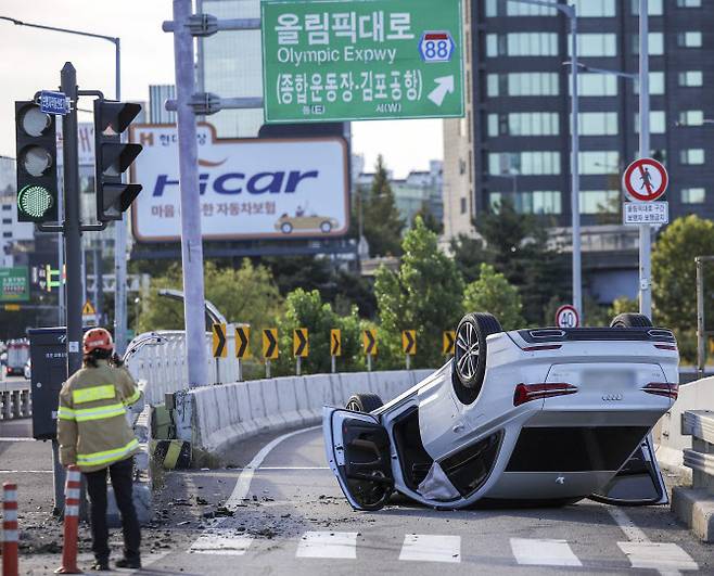 2일 서울 강남구 한남대교 남단 올림픽대로 출입로에 발생한 차량 전복 사고현장에 출동한 경찰 및 소방대원들이 사고 조사를 하고 있다. (사진=연합뉴스)