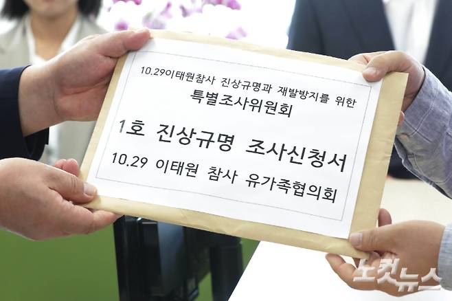 2일 오후 서울 중구 10.29 이태원참사 진상조사와 재발방지를 위한 특별조사위원회 앞에서 열린 '1호 진상규명 조사신청 접수 기자회견'에 참석한 이태원참사 유가족협의회 이정민 운영위원장이 송기춘 특조위원장에게 1호 진상규명 조사 신청서를 접수하고 있다. 황진환 기자