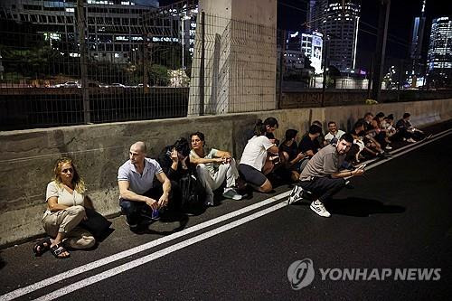 1일(현지시간) 공습경보 사이렌에 대피해있는 텔아비브 시민들 [로이터=연합뉴스. 재판매 및 DB 금지]