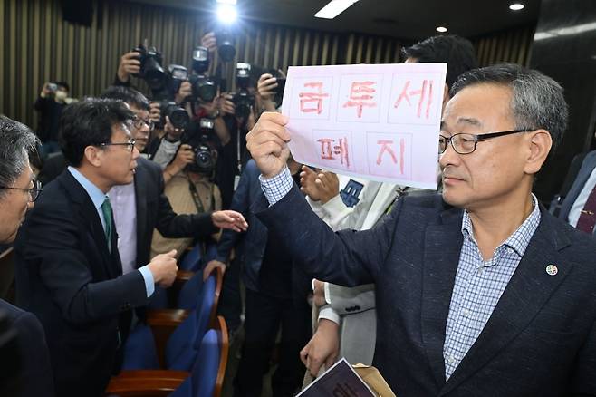 금투세 폐지를 주장하는 한국주식투자자연합회 회원들이 24일 국회 더불어민주당 의원총회장에서 토론에 참석시켜 달라며 항의하고 있다. 사진=한국경제신문