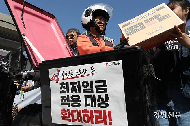 박정훈 공공운수노조 부위원장이 지난 5월8일 서울 광화문 광장에서 열린 최저임금 투쟁계획 발표 기자회견 중 배달노동자 요구를 배달통에 넣는 퍼포먼스를 하고 있다. 정효진 기자