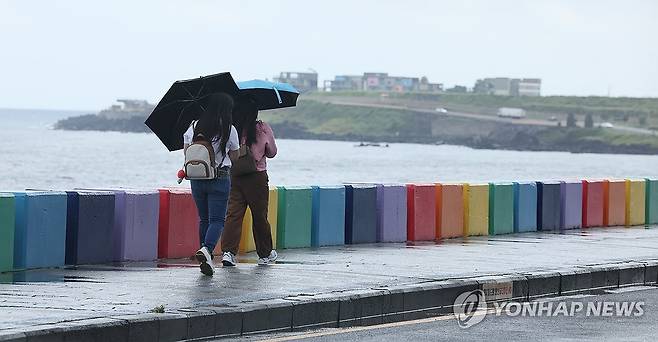 비 내리는 제주 (제주=연합뉴스) 박지호 기자 = 25일 오전 제주시 도두동 무지개해안도로를 찾은 관광객들이 바닷가 정취를 즐기고 있다. 2024.9.25 jihopark@yna.co.kr