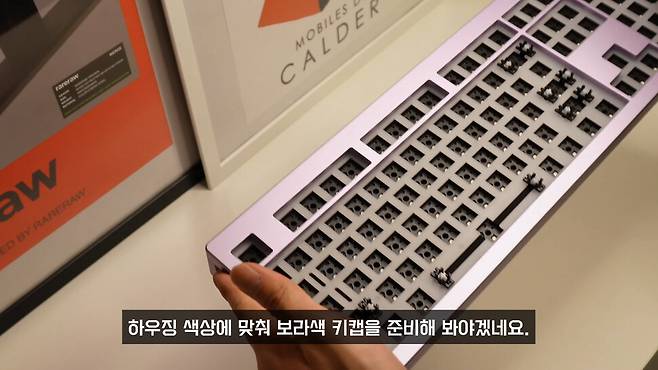 ‘몬스긱 엠파이브’(Monsgeek M5) 풀배열 커스텀 키보드를 만들고 있는 김상복씨. 들고 있는 것은 스위치와 키캡을 조립하기 전의 빈 하우징. 유튜브 채널 ‘뽀꾸’ 갈무리